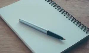 Notatnik i długopis gotowe do napisania podania o przyjęcie na praktyki studenckie.