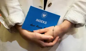 Kobieta trzyma indeks, zastanawiając się, czy studia liczą się do emerytury.
