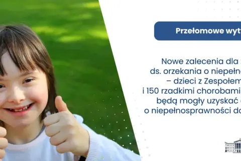Uśmiechnięta dziewczynka z zespołem Downa pokazuje kciuk w górę. Nowe zalecenia ds. orzekania o niepełnosprawności ułatwią uzyskanie orzeczenia.