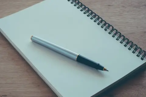 Notatnik i długopis gotowe do napisania podania o przyjęcie na praktyki studenckie.