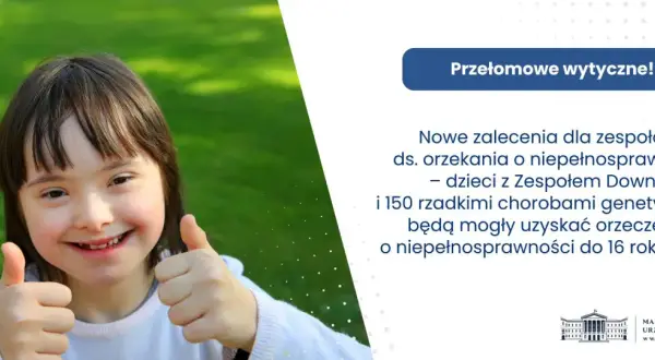 Uśmiechnięta dziewczynka z zespołem Downa pokazuje kciuk w górę. Nowe zalecenia ds. orzekania o niepełnosprawności ułatwią uzyskanie orzeczenia.