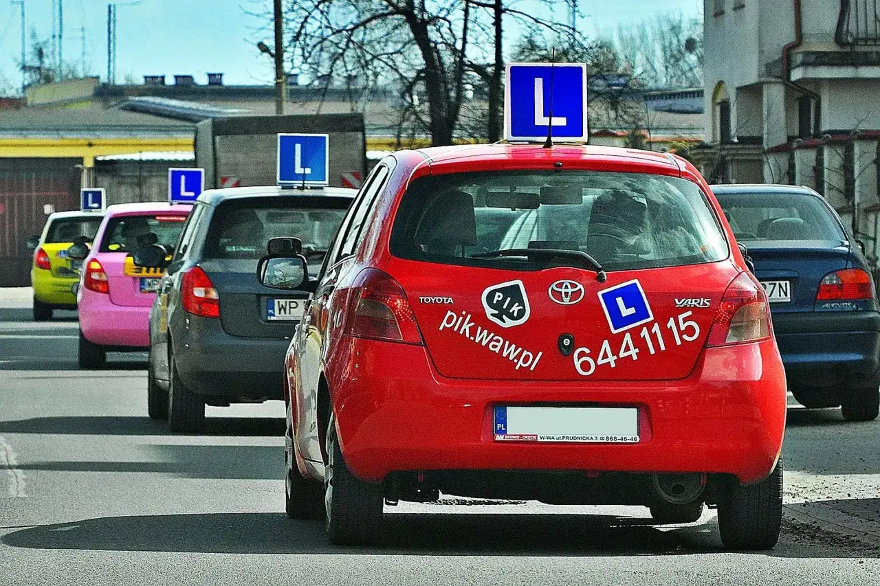 Czerwony samochód nauki jazdy z literą 