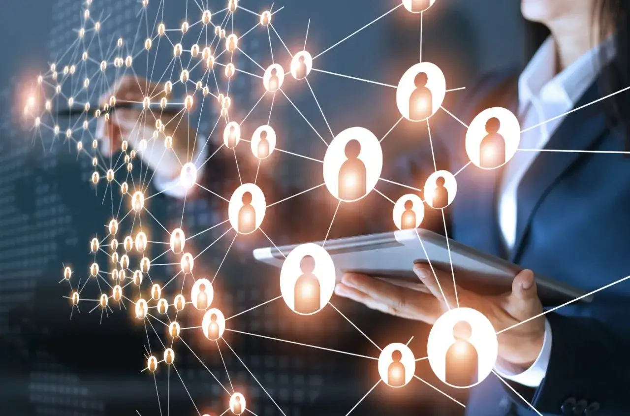 Sieć połączeń ludzi, symbolizująca networking co to. Bizneswoman z tabletem analizuje globalne relacje.
