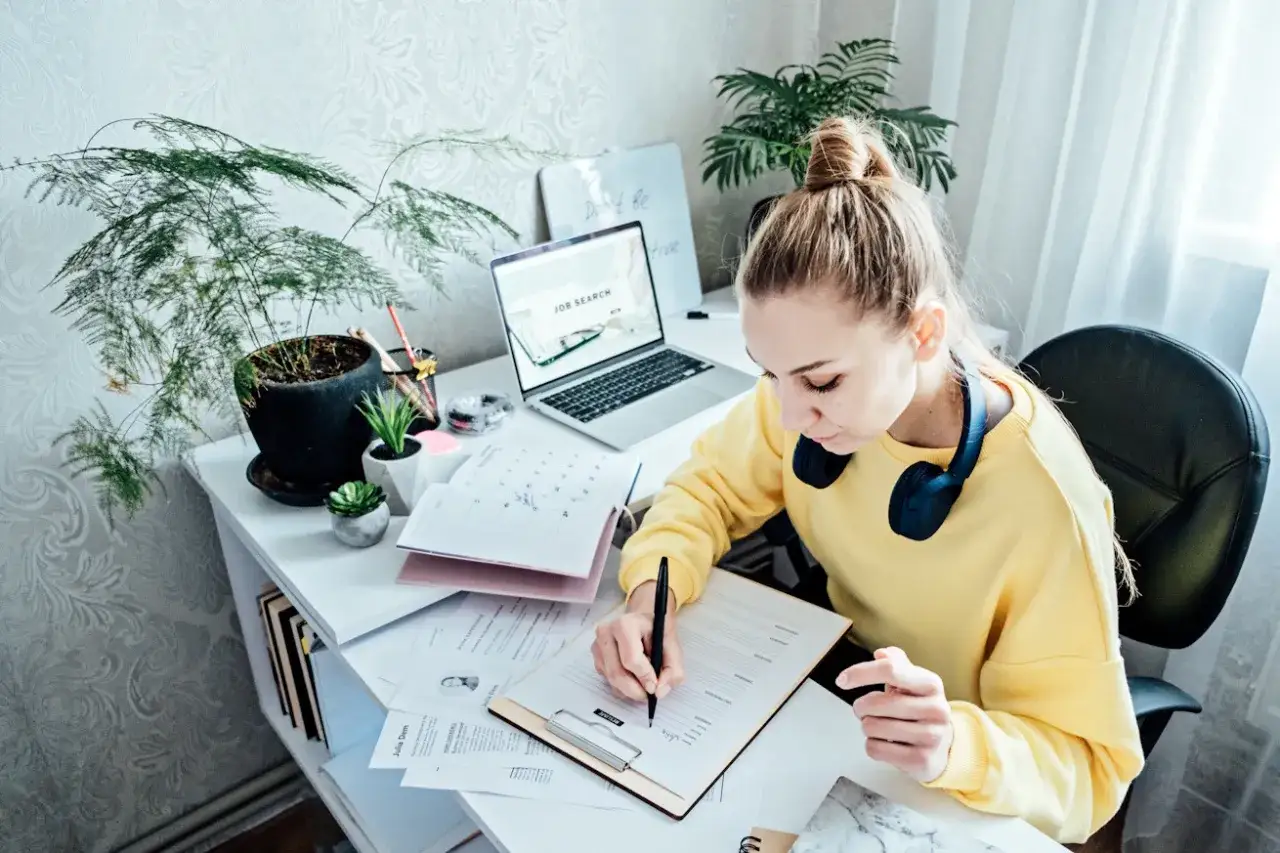 student piszący CV laptop